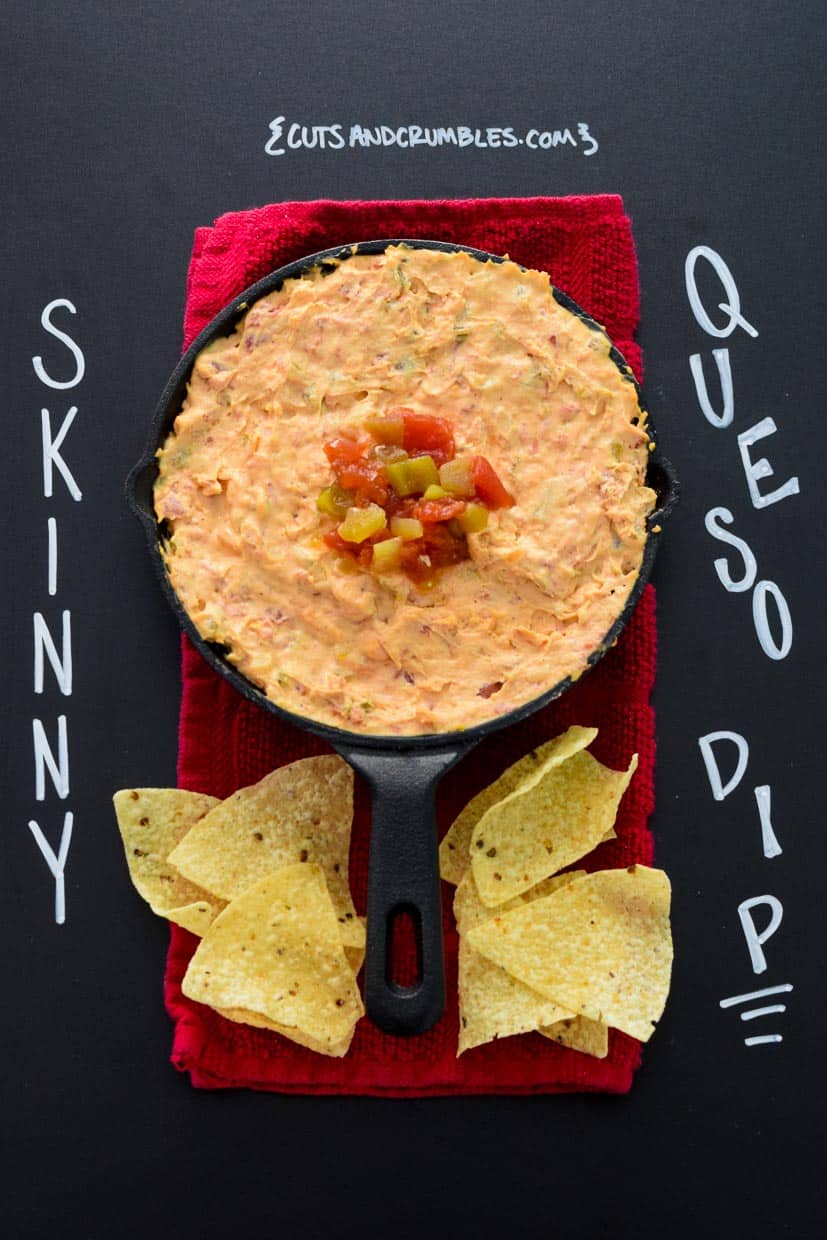 Skinny Queso Dip in cast iron pan on black chalkboard with title