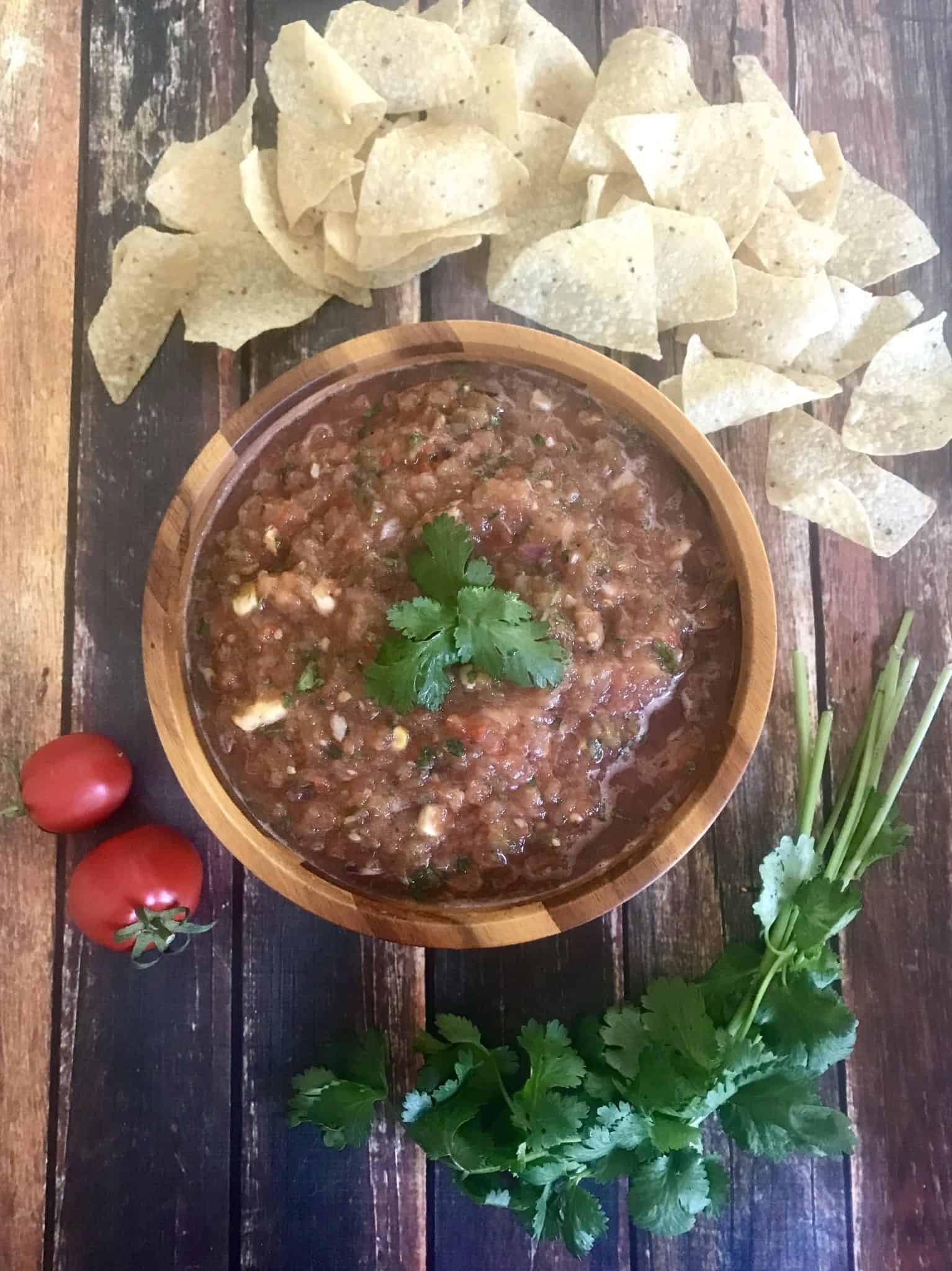 Smoked Salsa in brown bowl with ingredients and tortilla chips around it