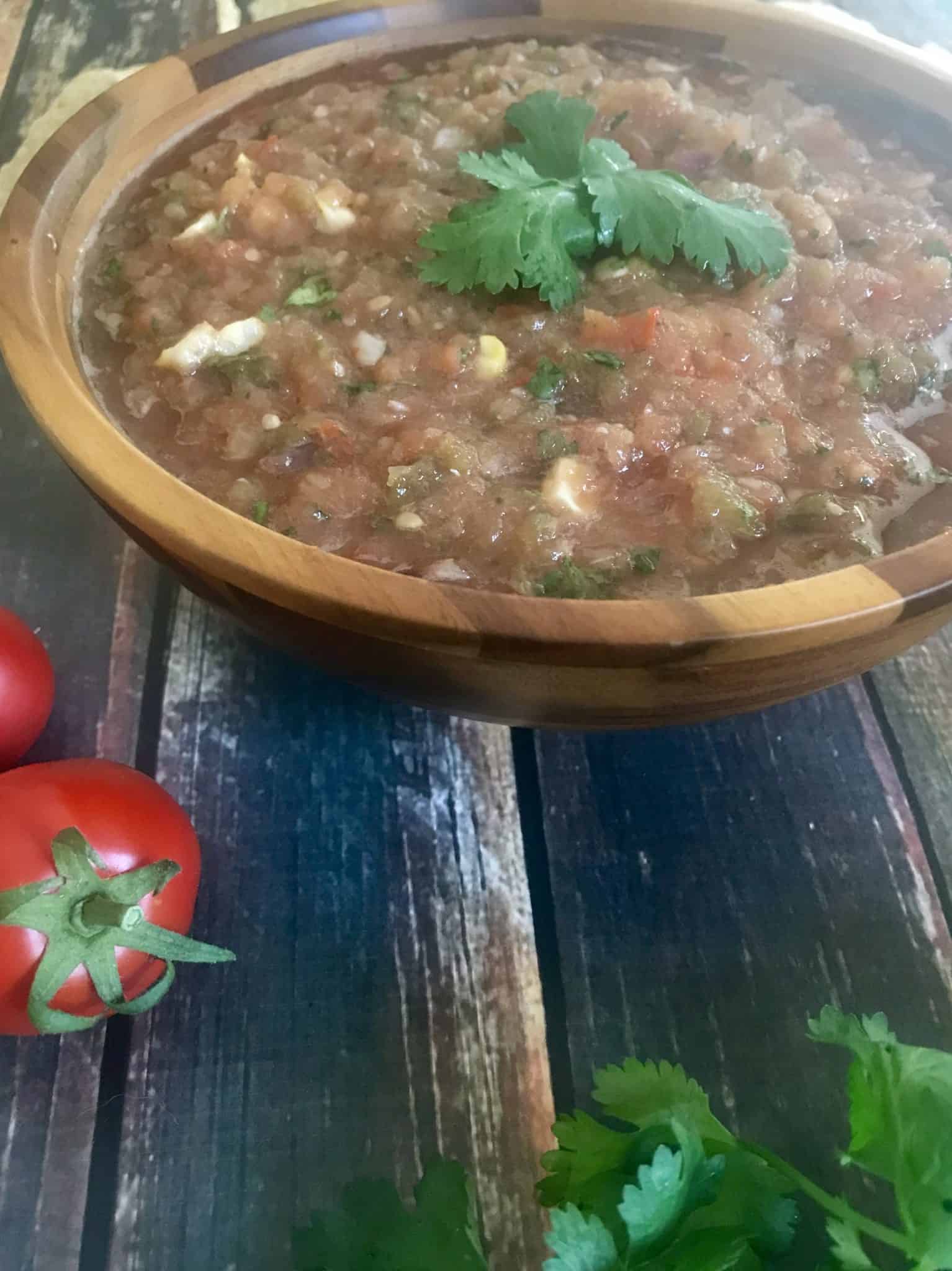 Close up view of smoked salsa in brown bowl topped with cilantro