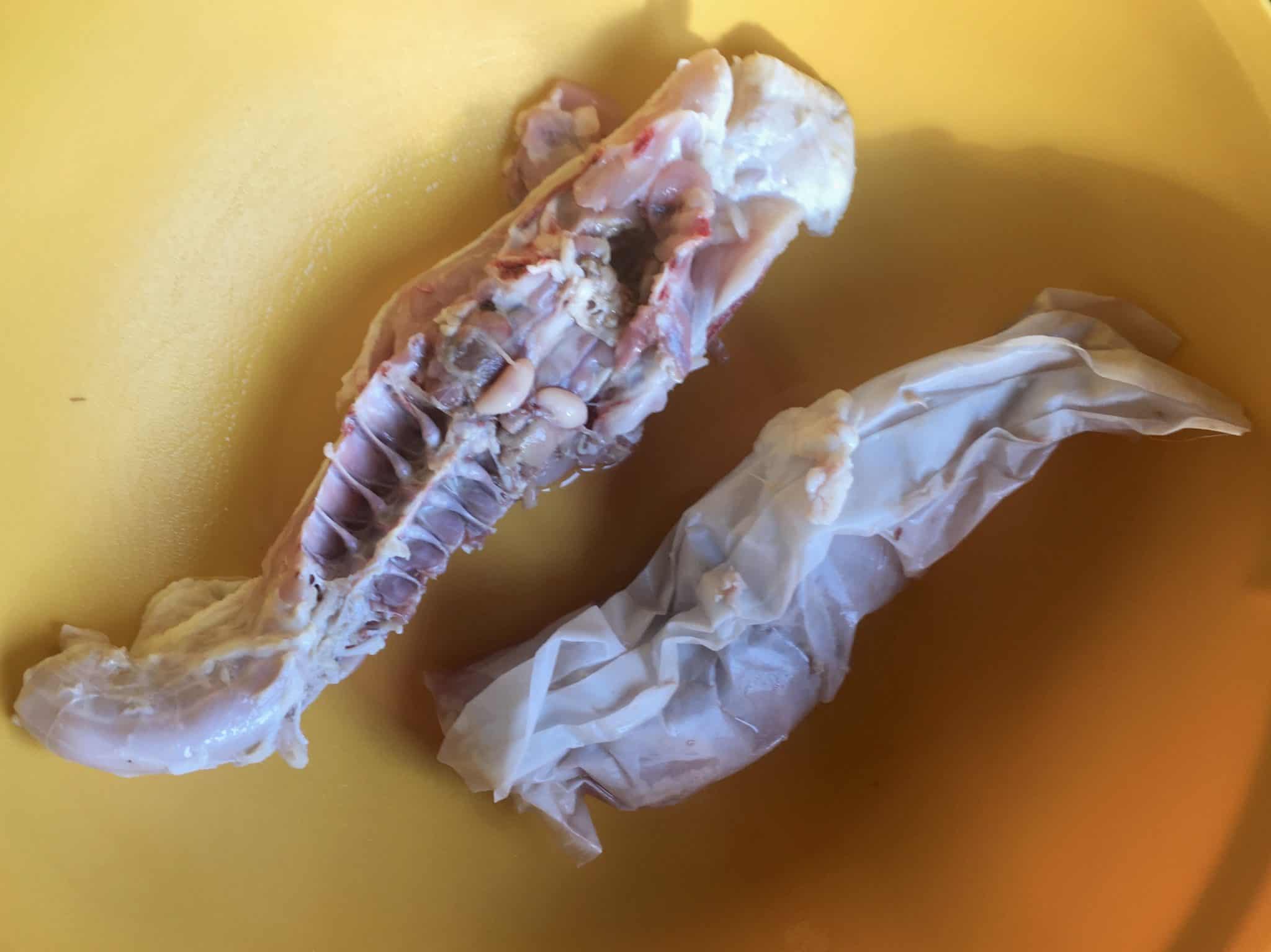 Chicken backbone and innards in yellow bowl overhead shot