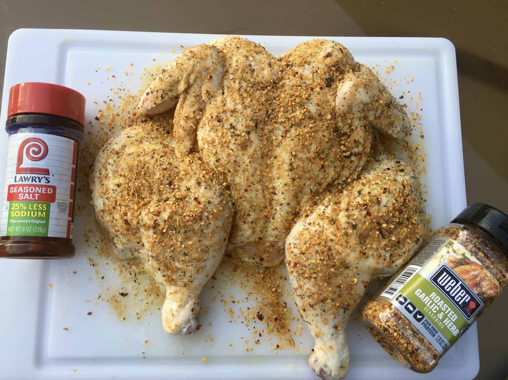 Spatchcocked Chicken on cutting board with seasonings overhead shot