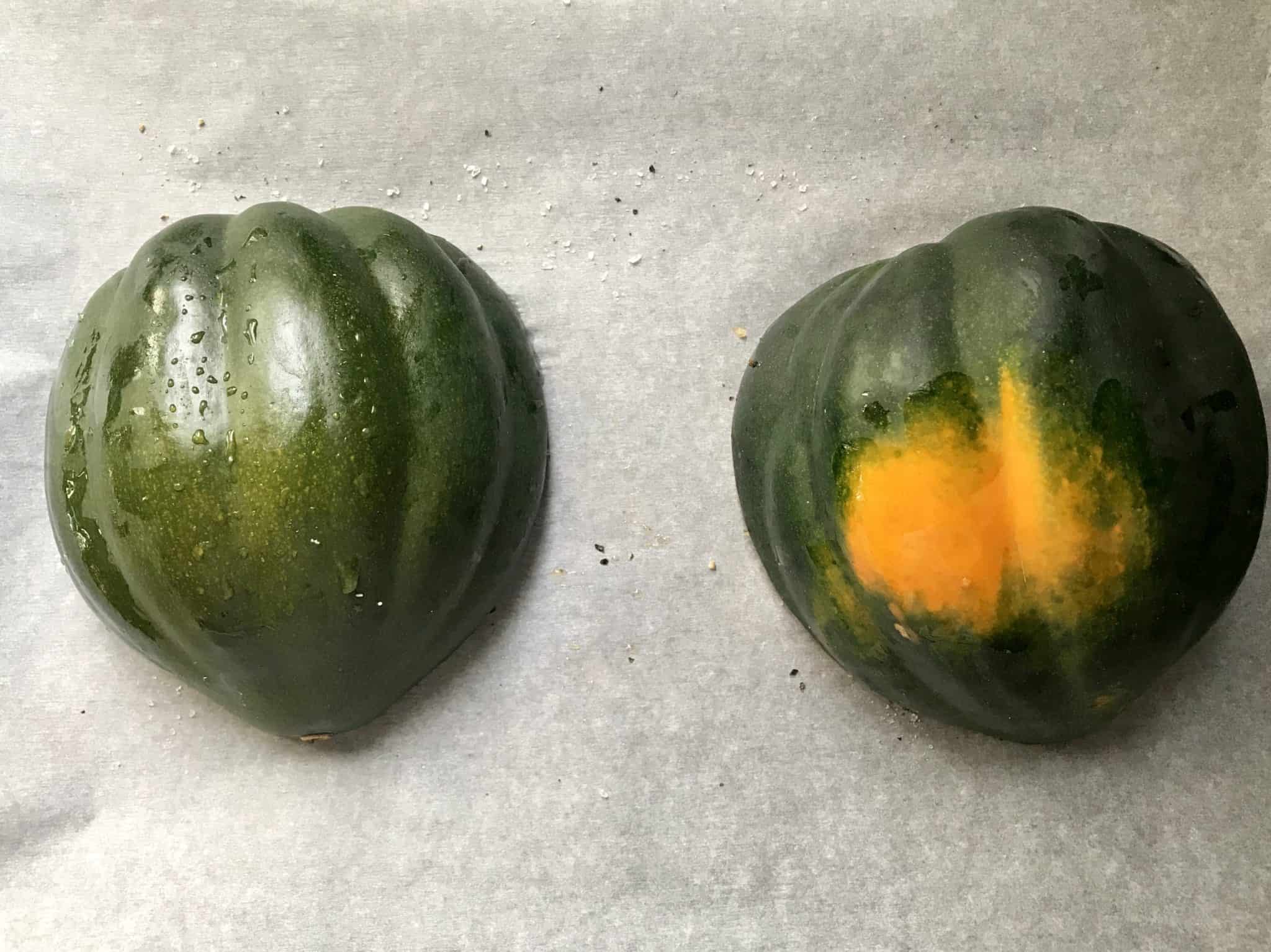 Acorn Squash on parchment paper lined baking sheet flesh side down