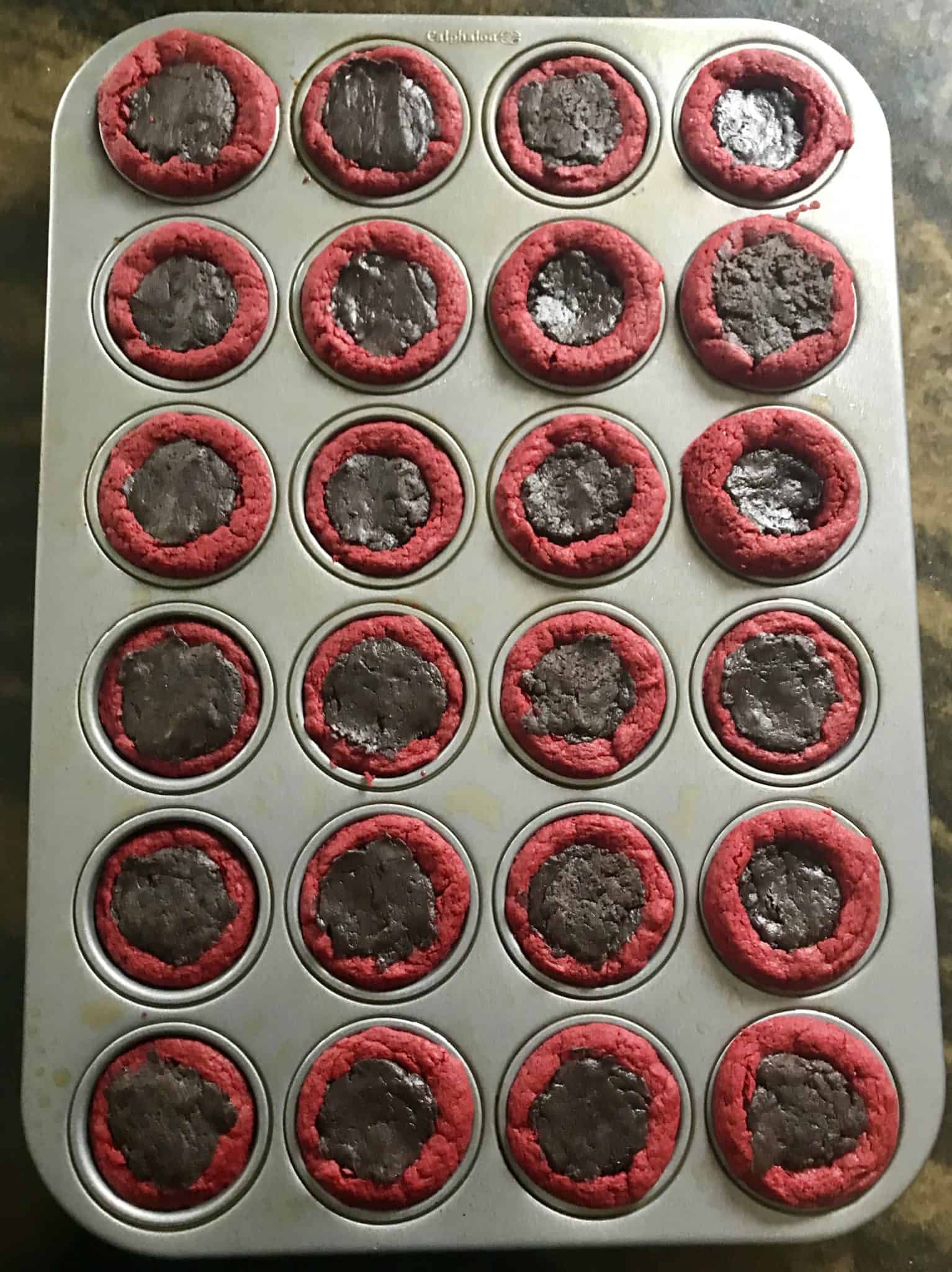 red velvet cake mix balls in mini muffin pan filled with Oreo truffle mix overhead shot
