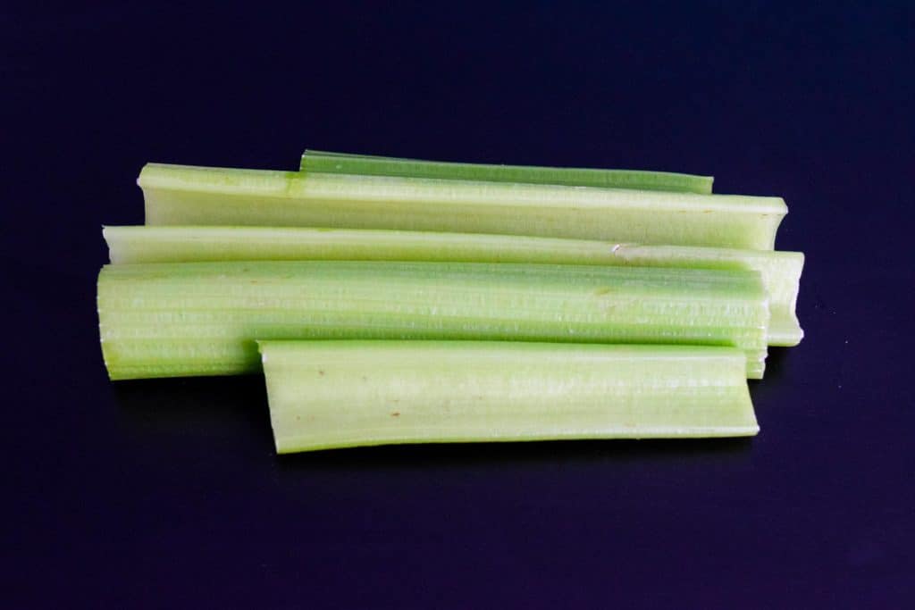sliced celery stalks on black background