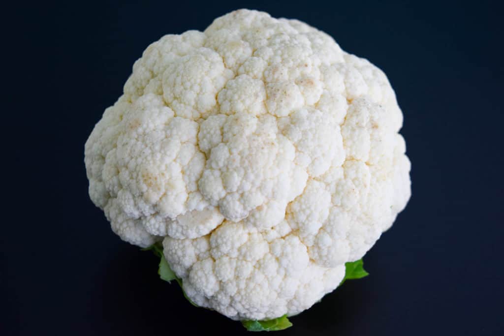 a head of cauliflower on black background