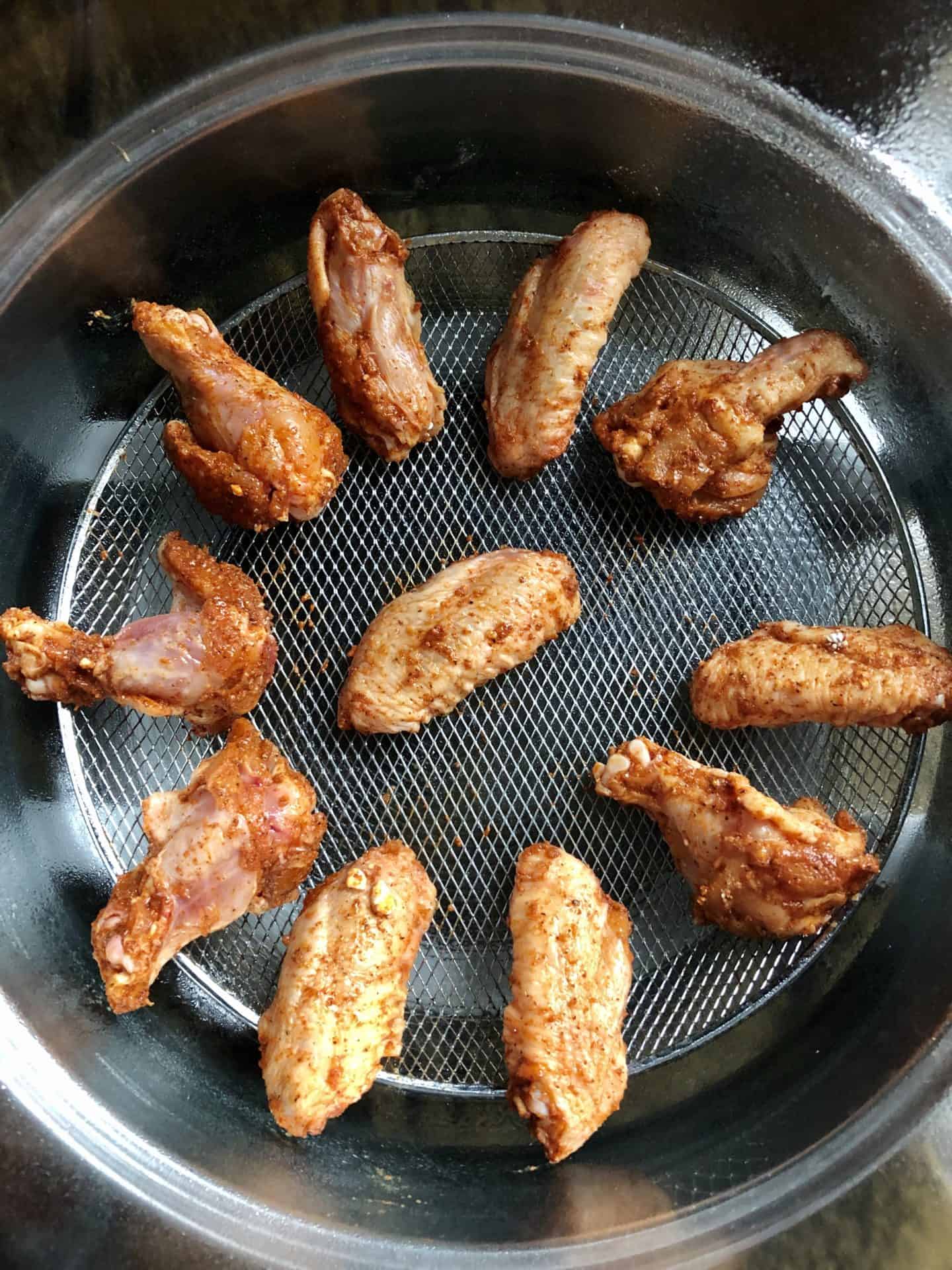 Chicken wings placed in air fryer basket ready to be fried overhead shot