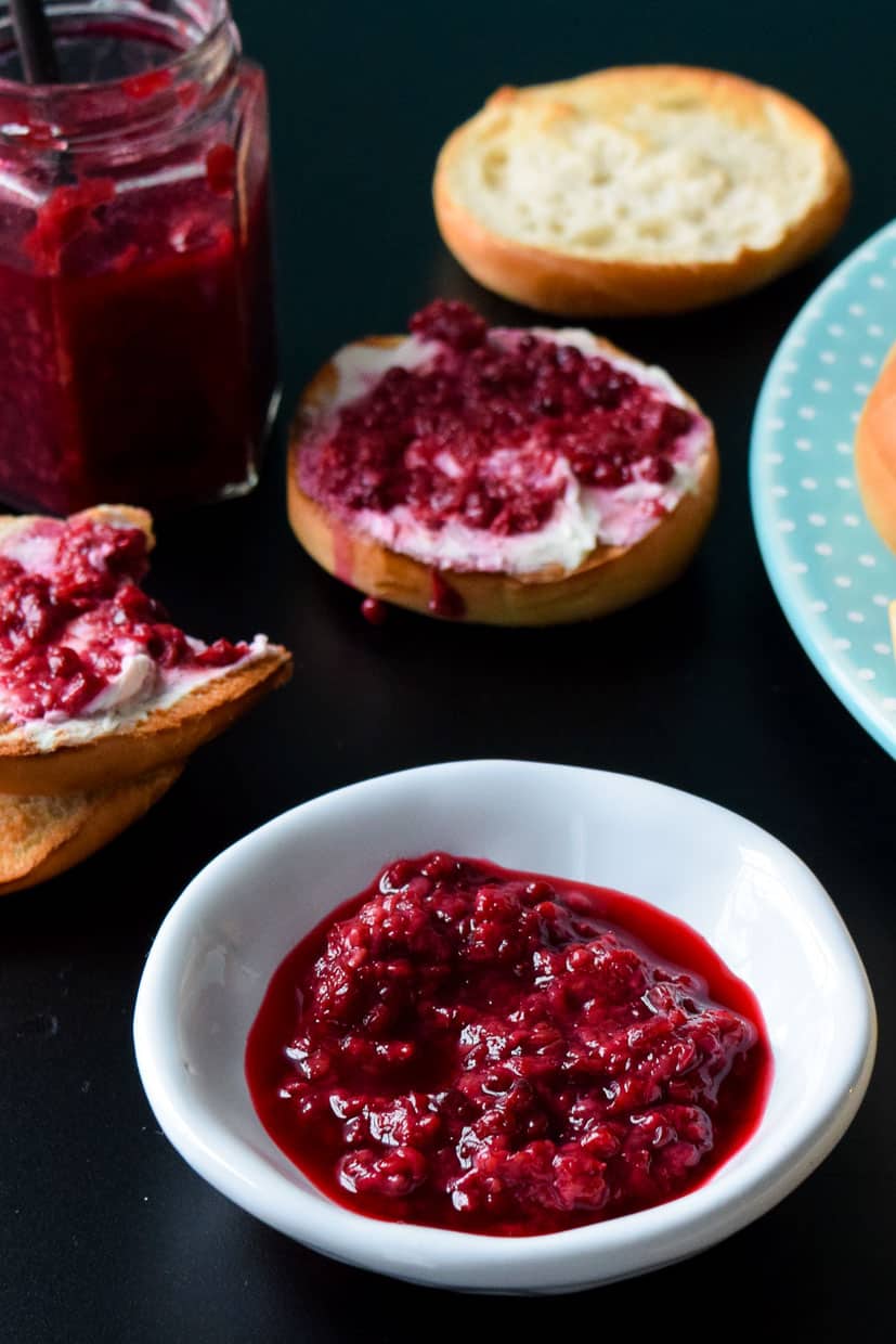 Fresh Mixed Berry Compote in bowl with mini bagels in background 