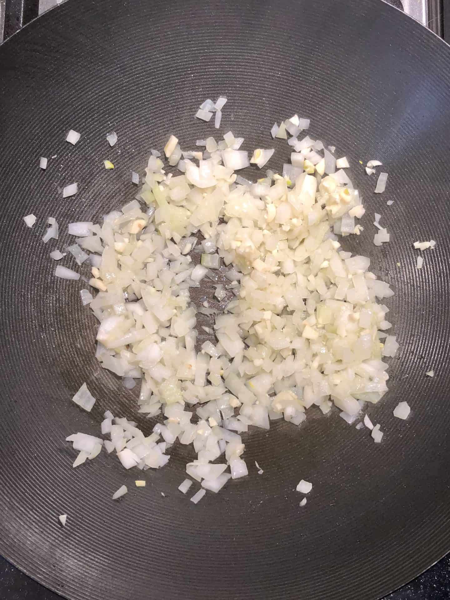 onions and garlic in wok pan