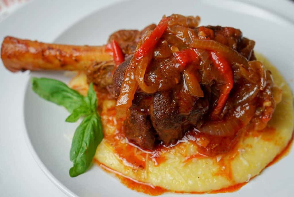 lamb shanks with polenta on white plate