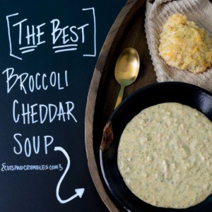 Broccoli cheddar soup in black chipped bowl with title written on chalkboard