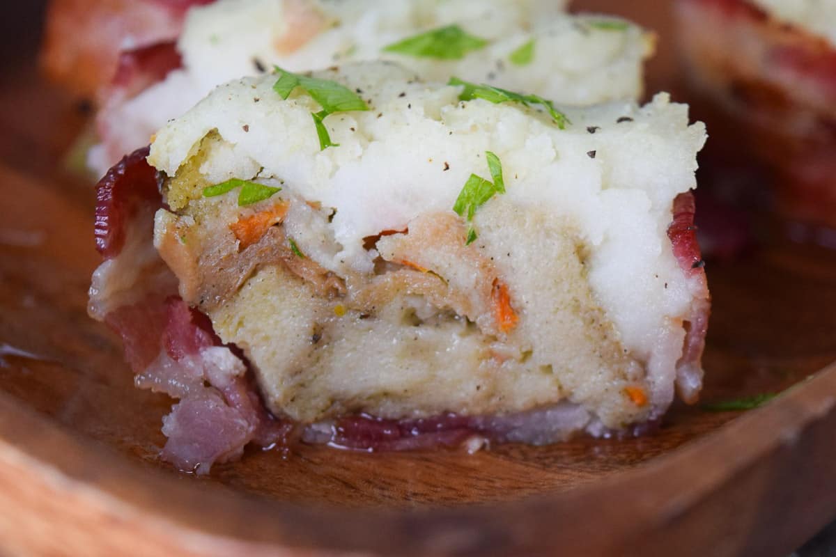 Close up view of cross section of bacon cup stuffed with stuffing and mashed potatoes 