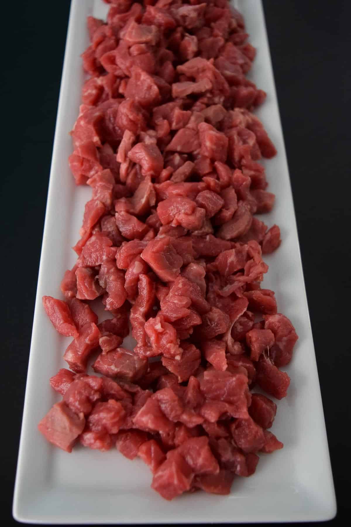 Raw beef stroganoff on white platter