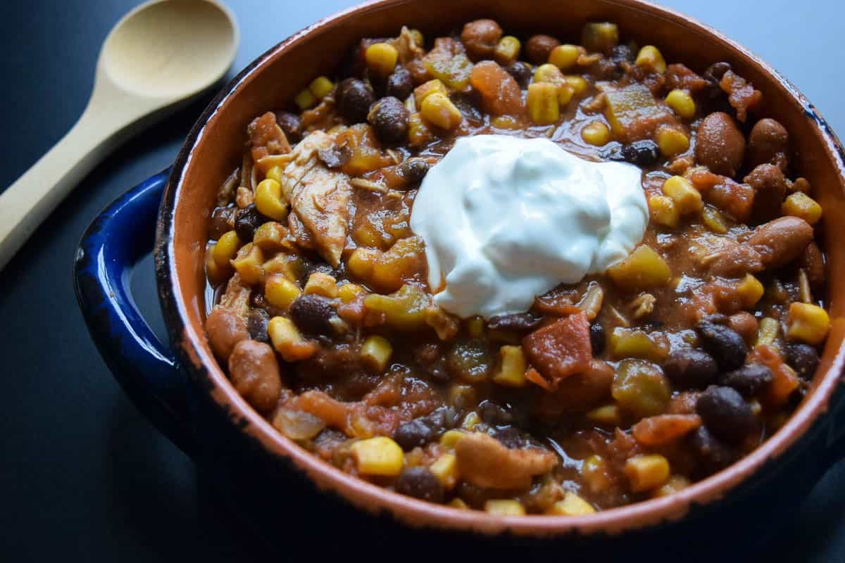 Crockpot Chicken Mexi-Chili in blue and orange bowl topped with sour cream