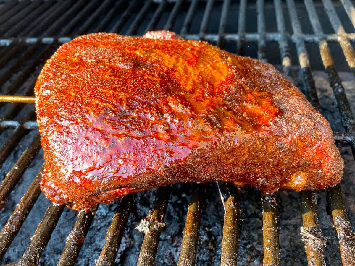 Smoked brisket sitting on grill up close view