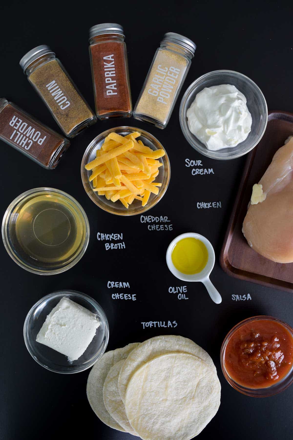 ingredients for baked chicken taquitos on black chalkboard