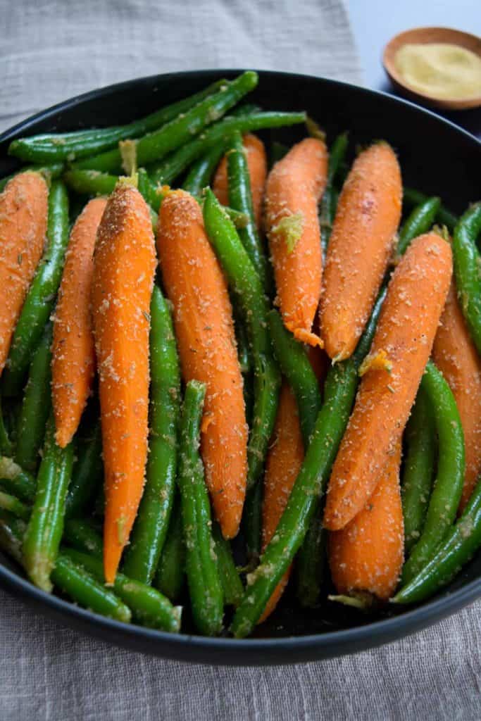 close up view of carrots and green beans coated in garlic and onion powder 