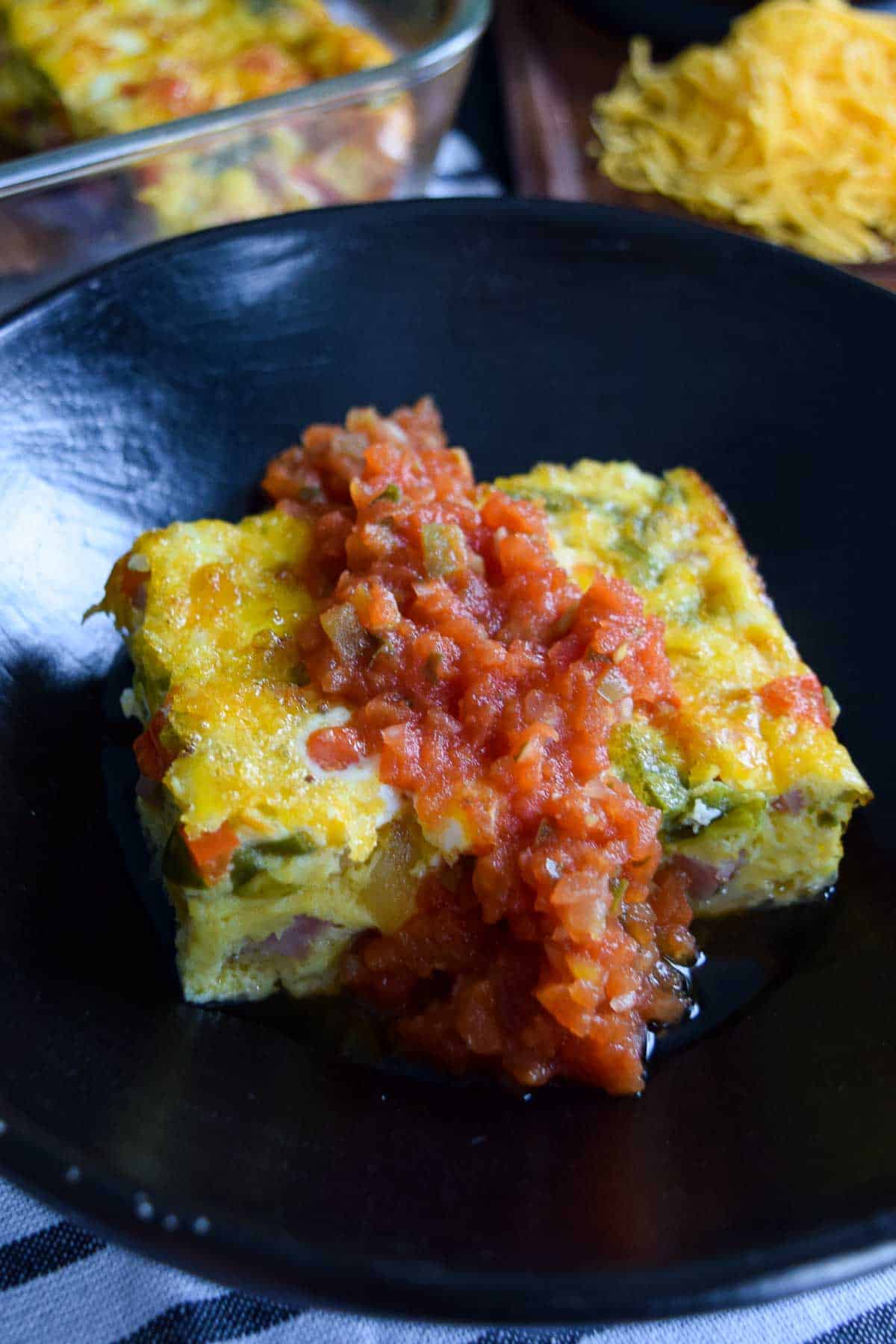 close up side view of baked western omelet covered in salsa