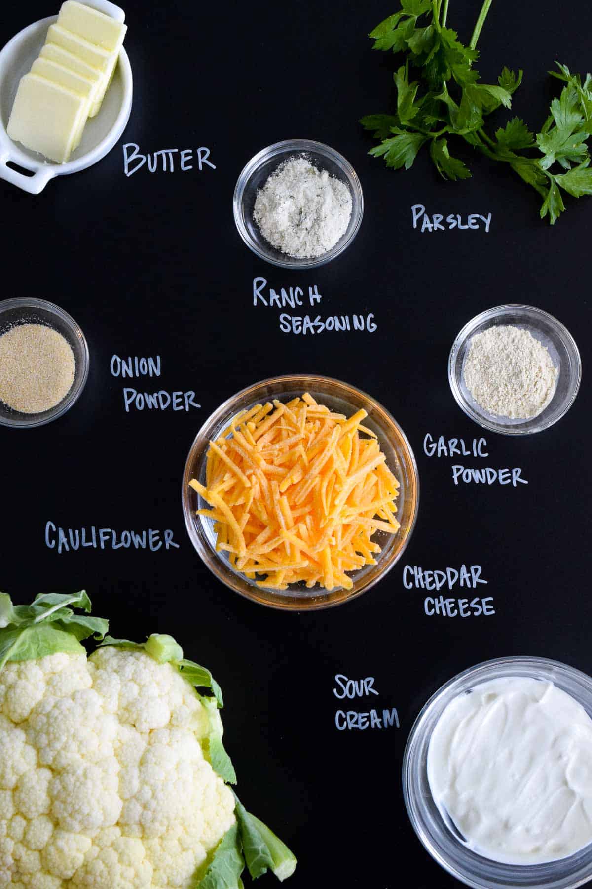 ingredients laid out on black chalkboard with names of each written in chalk