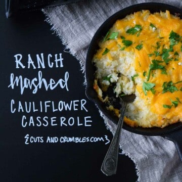ranch mashed cauliflower casserole in cast iron skillet with title written on black chalkboard